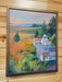 A framed landscape painting of a beekeeper working with beehives in a field, displayed on a light wood-paneled wall.