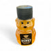 Bear-shaped honey bottle with black cap on a white background