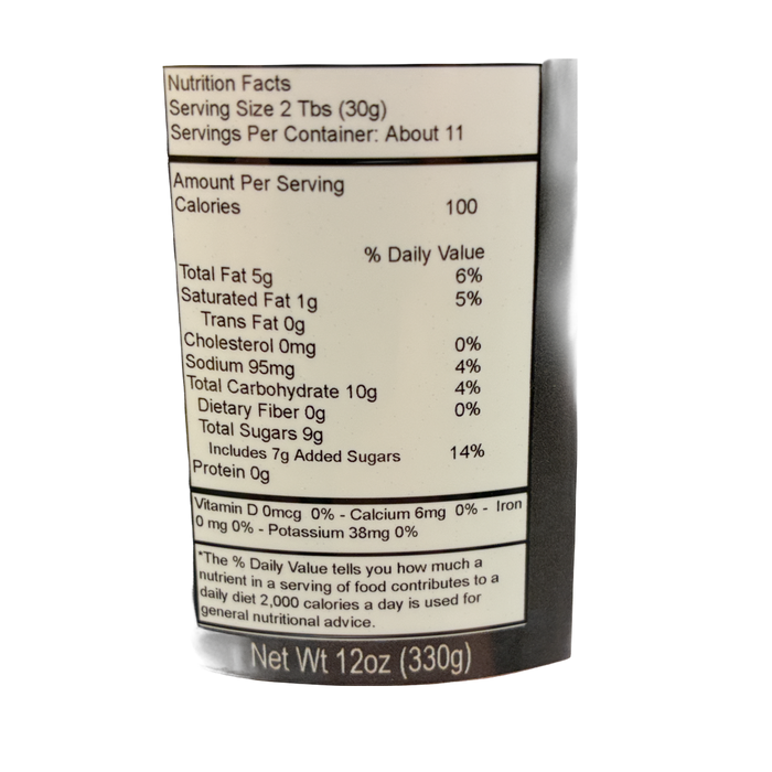 A close-up of a product's nutrition facts label showing serving size 2 Tbs (30g) and nutritional information per serving on a dark brown background.